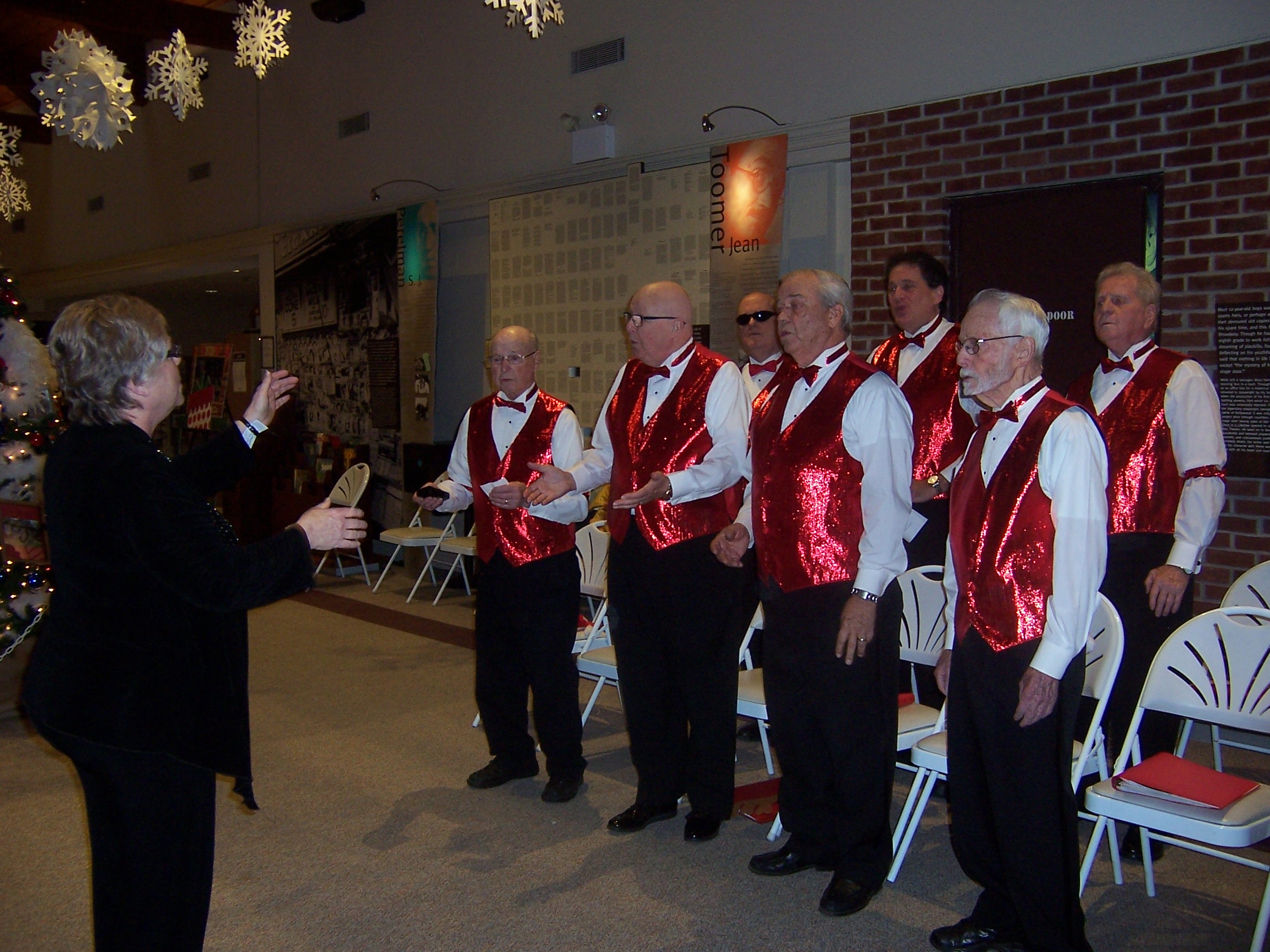 The chorus singing, onstage, in festive attire (1 of 4)